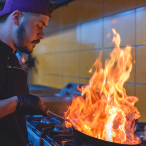 A cook cooking with fire