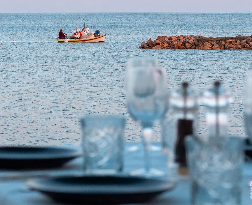 View from a seaside restaurant as a fisher boat is passing by