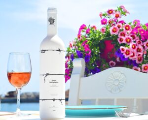 A white bottle of wine and colored flowers at zorbas seafood restaurant in Ierapetra/crete